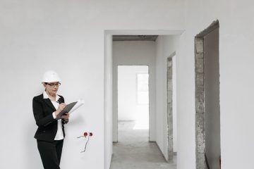 Boş dairede elinde panoyla kontrol yapan uzman