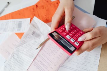 Hesap makinesiyle incelenen kağıt faturalar