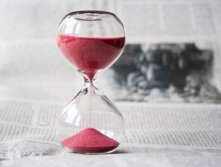 Gazete üzerinde kırmızı kumlu kum saati